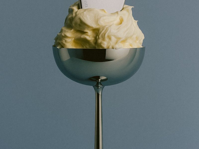 Frasco de sérum de niacinamida junto a un rostro con piel uniforme y luminosa.