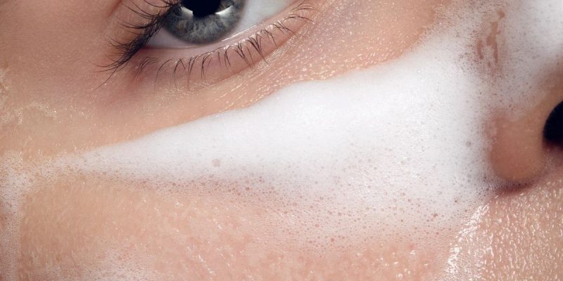 Mujer aplicando productos de cuidado facial para lograr una piel radiante y luminosa estilo Glass Skin.