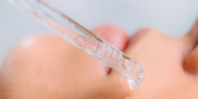 Frasco de sérum con niacinamida junto a un rostro con piel uniforme y luminosa tras su aplicación.