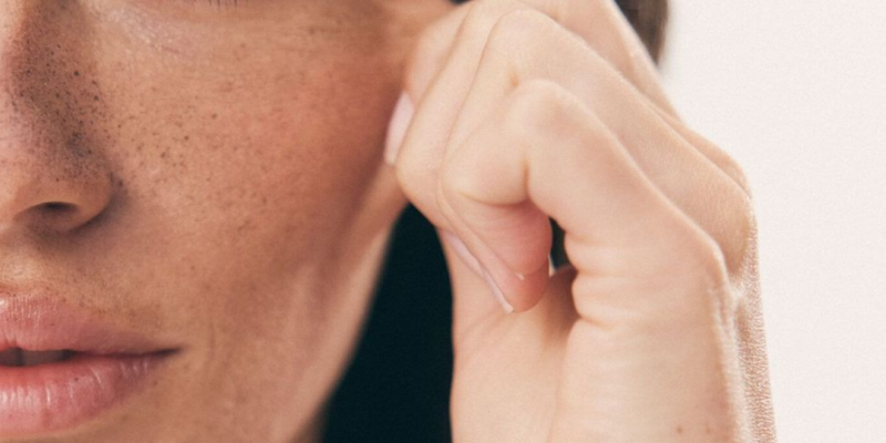 Frascos de sérum con niacinamida y retinol junto a un rostro con piel renovada y luminosa tras su aplicación.