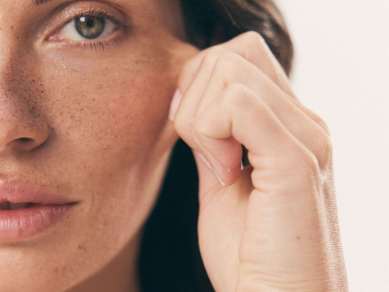 Frascos de sérum con niacinamida y retinol junto a un rostro con piel renovada y luminosa tras su aplicación.