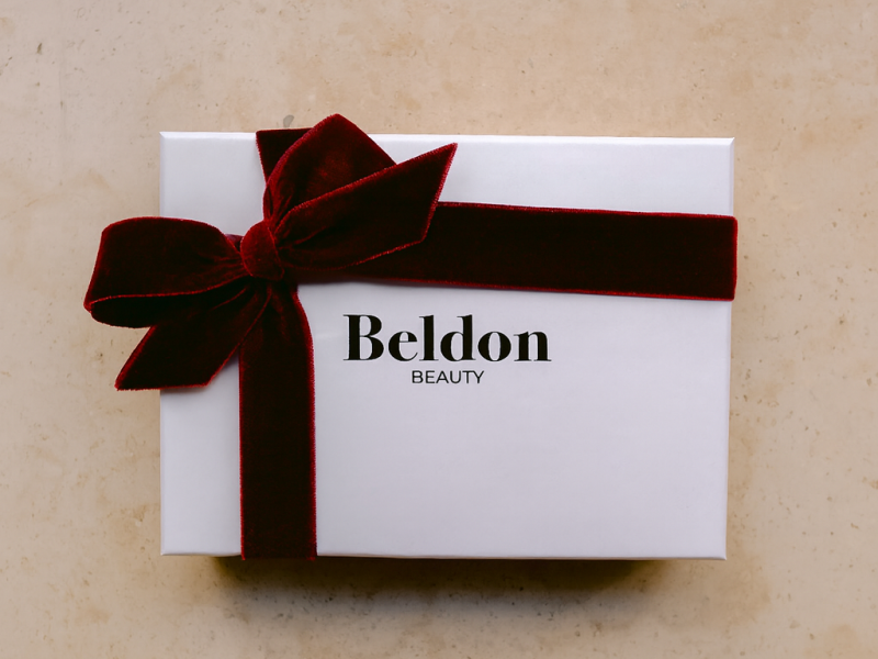 Tarjeta regalo de belleza sobre un fondo festivo, representando un regalo elegante y personalizado para Navidad.